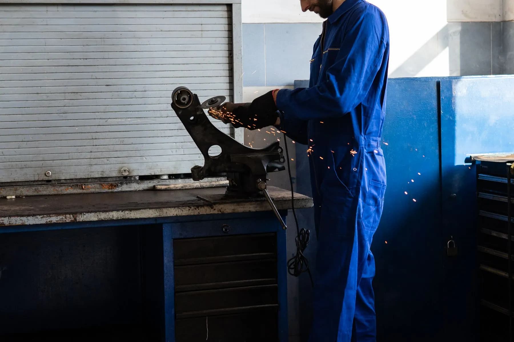 Mechanic working on a metal automotive component.