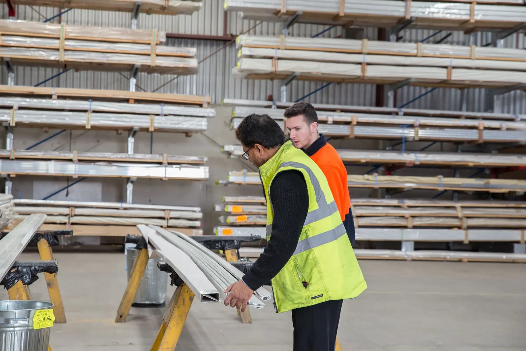 Workers inspecting construction materials in a warehouse.
