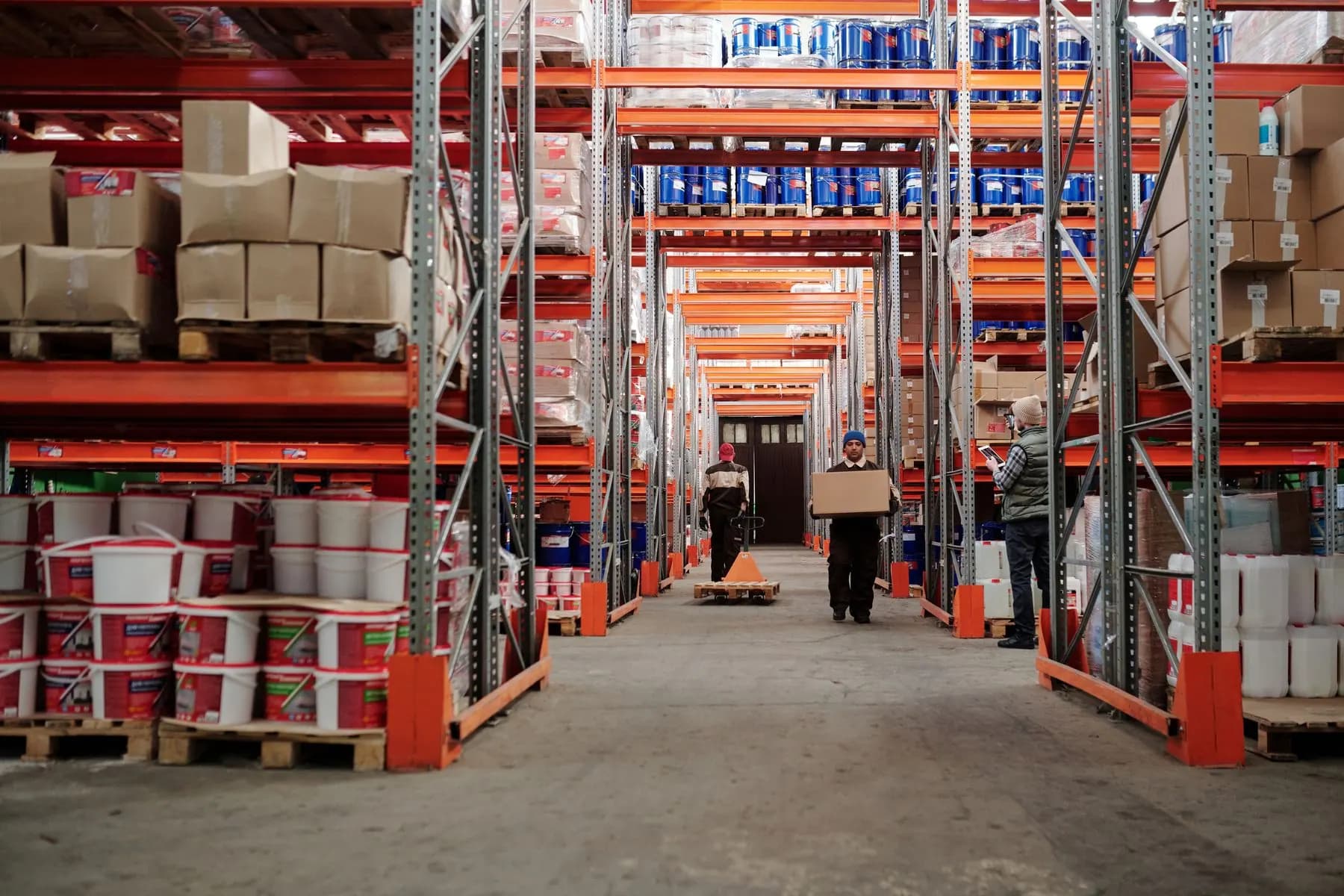 Workers in a warehouse handling consumer goods and boxes.
