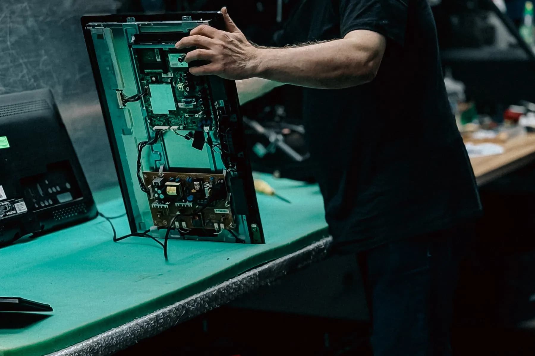 Technician inspecting a circuit board in a workshop.