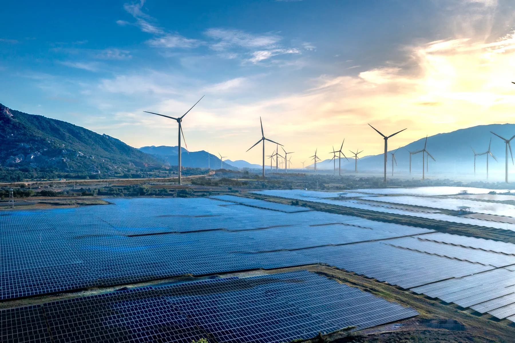 Solar panels and wind turbines in a renewable energy landscape.