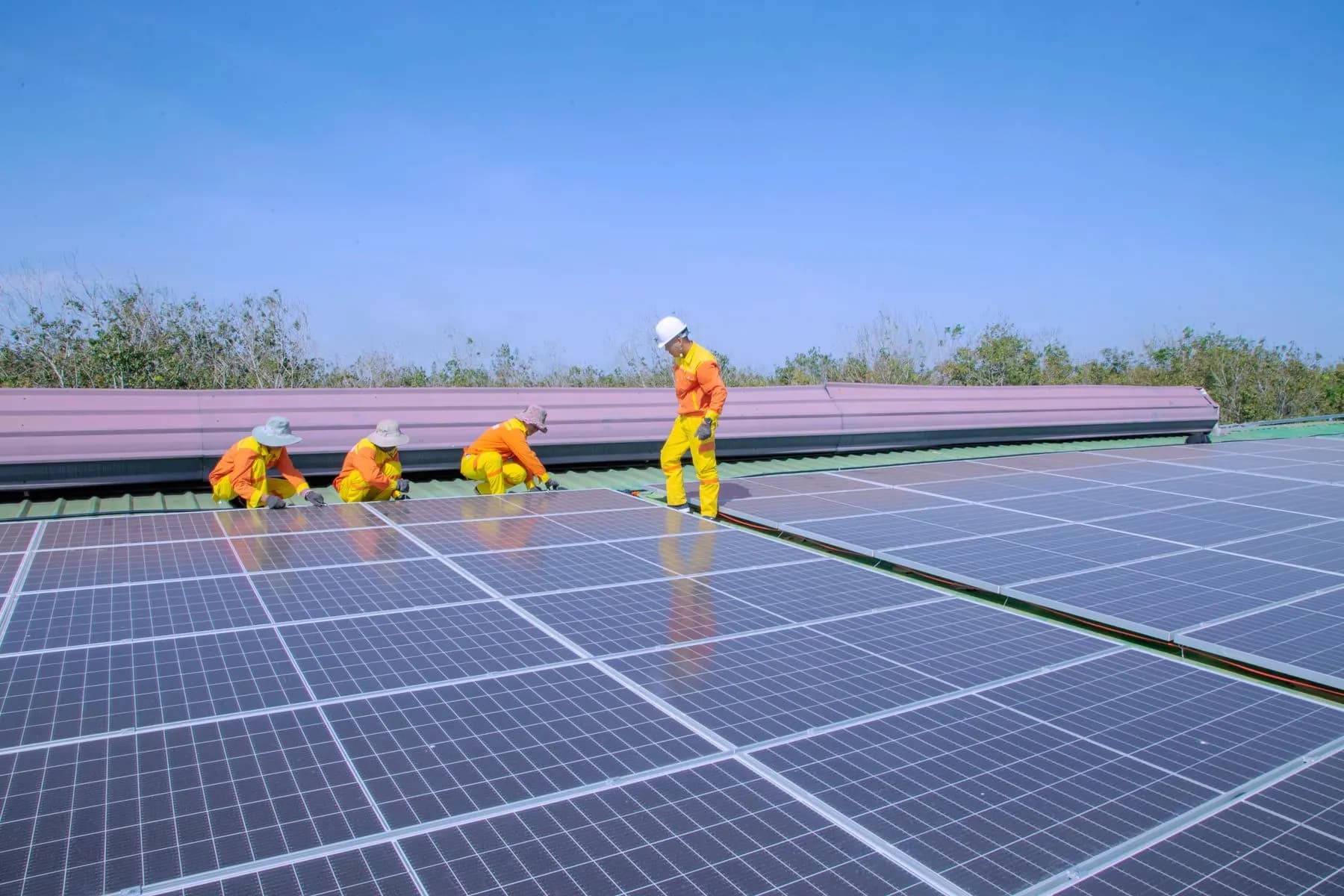 Technicians installing solar panels on a rooftop.