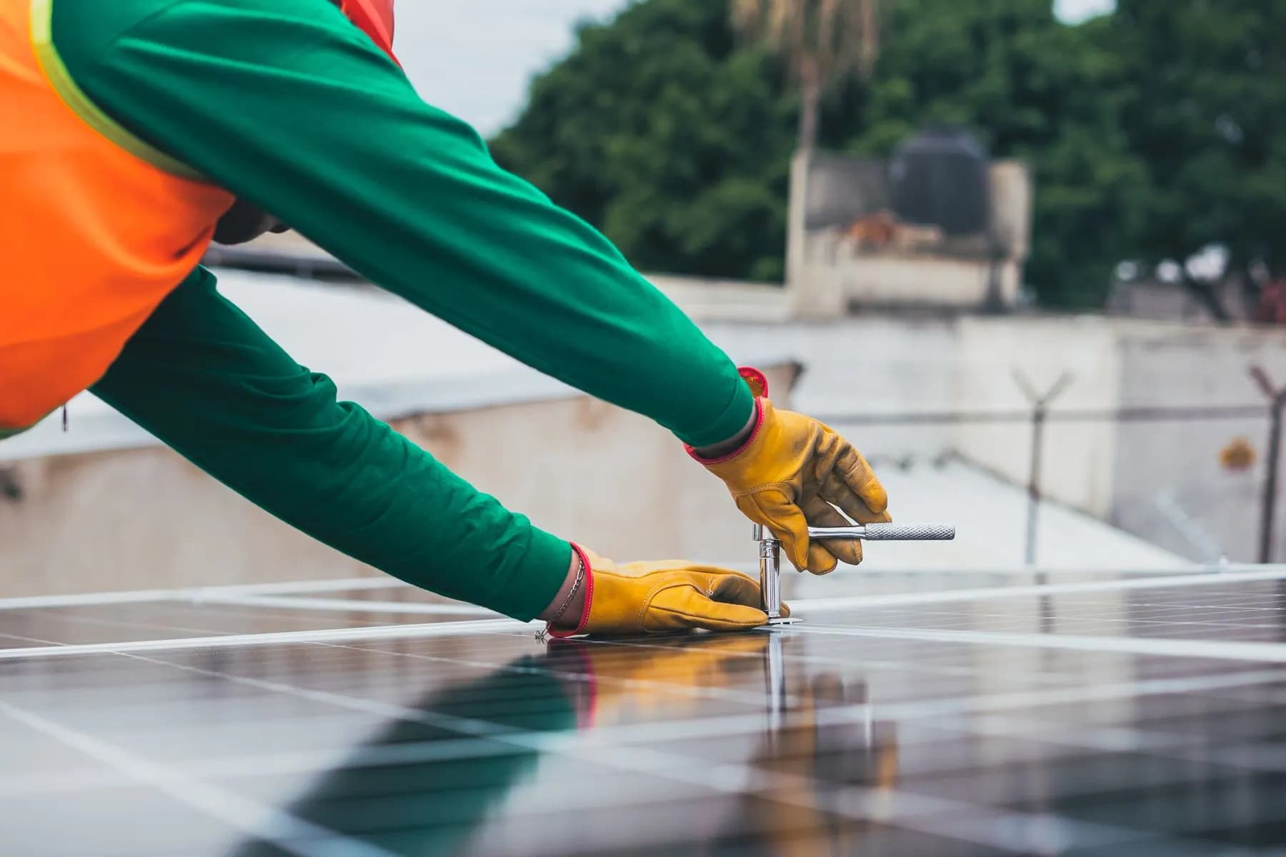 Solar technician working with tools near solar panels.